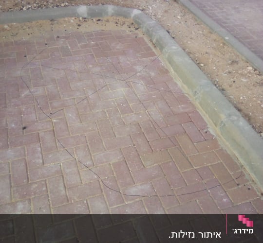 סימון אזור נזילה תת קרקעית על גבי ריצוף אבנים משתלבות